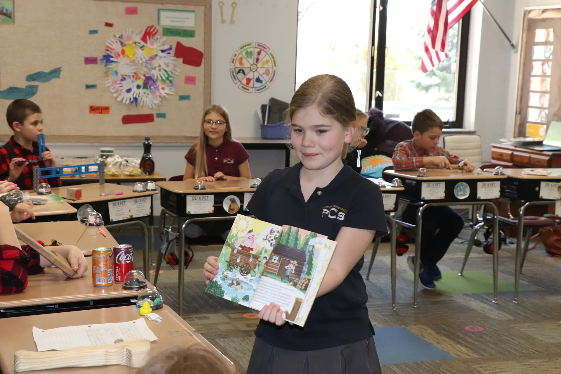 A student showing off her artwork in the classroom