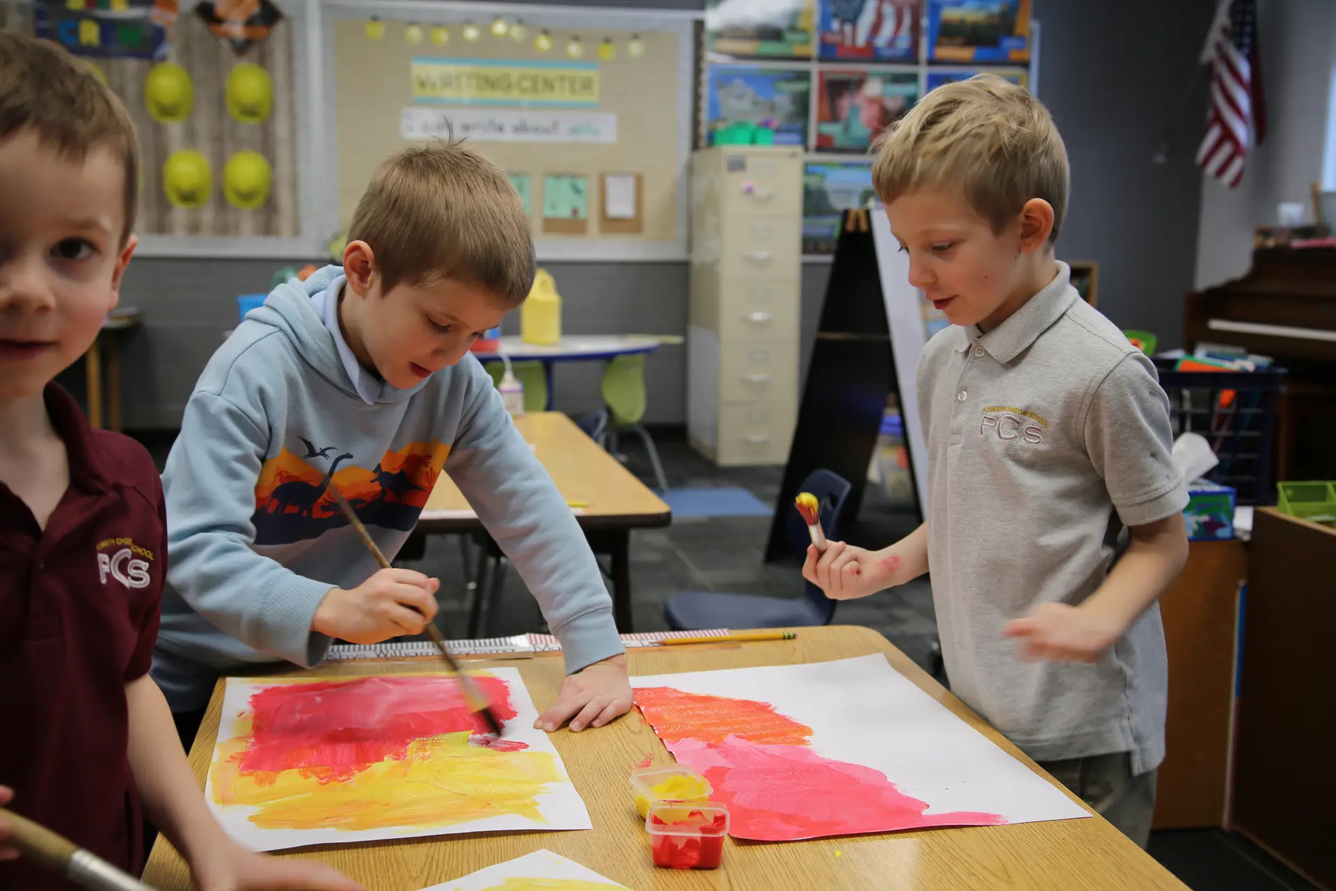 Students painting at a classroom table
