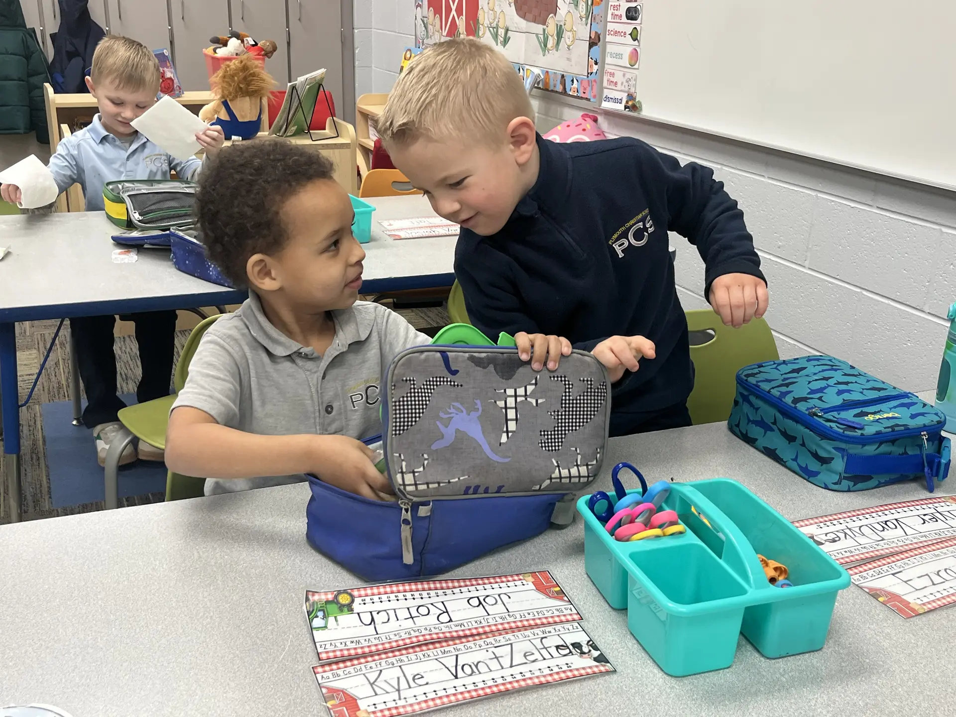 Two young students opening their pencil boxes