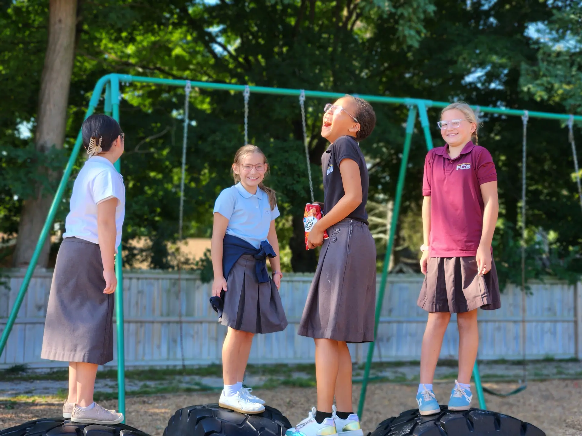 Students standing on the swing set tires at recess